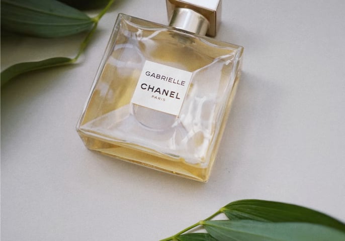 Chanel perfume bottle surrounded by leaves